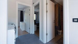 A modern hotel room with a bathroom, a small kitchen area, and a bedroom visible through an open door. - modu’s semi-detached houses (marmaris)