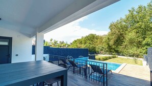 A modern outdoor patio with a pool, wooden deck, and seating area. - modu’s semi-detached houses (marmaris)