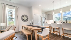 A modern kitchen with a dining area, wooden furniture, and large windows. - UNCC 4BR | Pet-Friendly Stay (Charlotte)