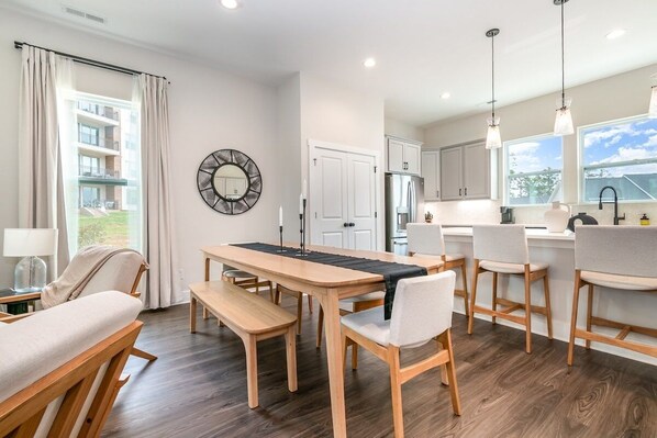 Una cocina moderna con comedor, muebles de madera y ventanas amplias.