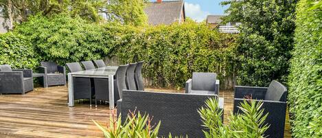 Eine Terrasse im Freien mit Korbmöbeln und einer Holzterrasse.