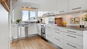A modern kitchen with white cabinetry, stainless steel appliances, and wooden flooring. - Amazing home in Otterup with WiFi (Otterup)