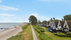 A row of beachside cottages with a pathway leading to the beach. - Amazing home in Otterup with WiFi (Otterup)
