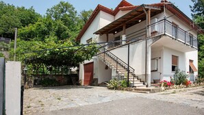A two-story house with a balcony, a staircase, and a garden area. - Villa 'Chiara' with Mountain View and Private Terrace (Lumarzo)