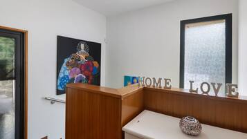 Een receptiebalie met een houten afwerking, een glazen deur en een muur met een 'HOME LOVE' bord.