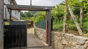A stone wall, a metal gate, and a vineyard in the background. - Holiday Home 'Cevidade' with Lake View, Wi-Fi and Air Conditioning (Melgaço)