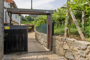 A stone wall, a metal gate, and a vineyard in the background. - Holiday Home 'Cevidade' with Lake View, Wi-Fi and Air Conditioning (Melgaço)