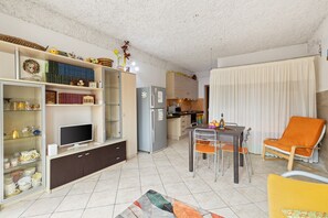 A modern kitchen with a refrigerator, dining table, and chairs.