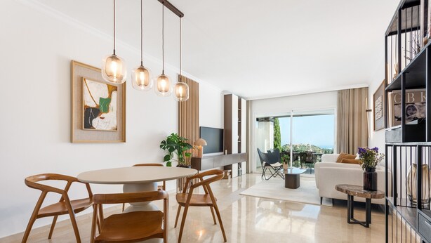 A modern living room with a dining area, a sofa, a TV, and a balcony with a view. - Apartment 'La Quinta Golf' with Sea View, Wi-Fi and Air Conditioning (Unknown)