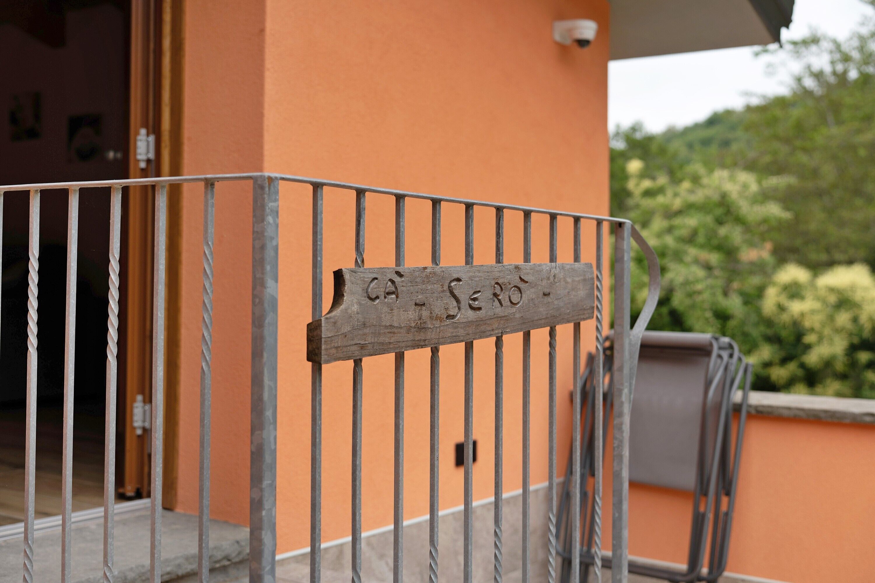 A metal gate with a wooden sign that reads 'CA SERO.'