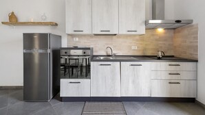 Eine moderne Küche mit einem Edelstahl-Kühlschrank, einem eingebauten Backofen und einem Gasherd.