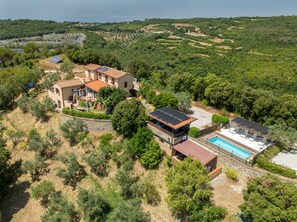 A villa with a swimming pool, terraced gardens, and a view of the surrounding hills. - Studio 'Oltremare - Casa Nocolino' with Shared Pool, Wi-Fi and Air Conditioning (Riparbella)