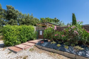 A garden with a wooden pergola, a gravel pathway, and various plants. - Studio 'Oltremare - Casa Fornelli' with Shared Pool, Wi-Fi and Air Conditioning (Riparbella)