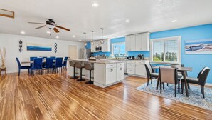 A modern kitchen with white cabinets, a central island, and pendant lighting.