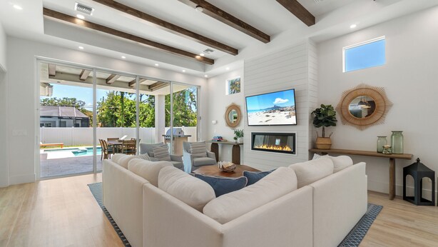 A spacious living room with a large sectional sofa, a flat-screen TV, and a fireplace. - NEW! Luxe Escape w/ Pool & Spa - Close to Beach (Naples)