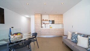 A modern apartment with a dining area, kitchenette, and living space.