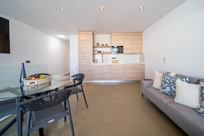 A modern apartment with a dining area, kitchenette, and living space. - Vacation 'Kay Lava' with Mountain View, Wi-Fi and Air Conditioning (Caleta de Famara)