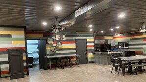 A modern kitchen with a bar area, featuring striped walls, a tiled floor, and contemporary appliances.