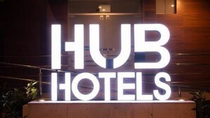 Une enseigne pour « IHUB HOTELS », au design moderne, avec des lettres illuminées.