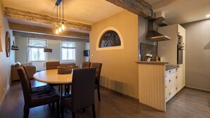 Un espace repas comprenant une table ronde, des chaises et un luminaire suspendu.