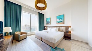 Camera d'albergo con un letto grande, una scrivania, una sedia e vista sulla città.