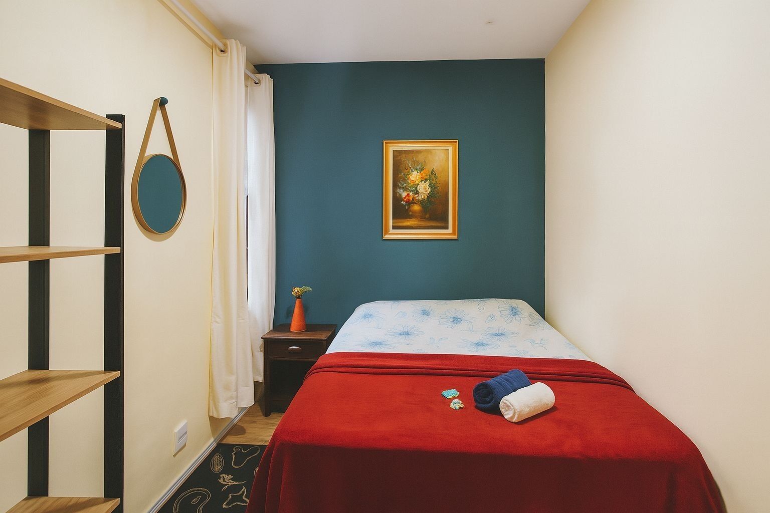 Una camera da letto con un letto, un comodino, una cassettiera, uno specchio e un quadro appeso al muro.