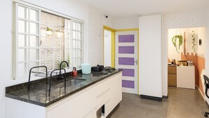 Una cucina moderna con un'ampia finestra, mobili bianchi e un design di porta originale.
