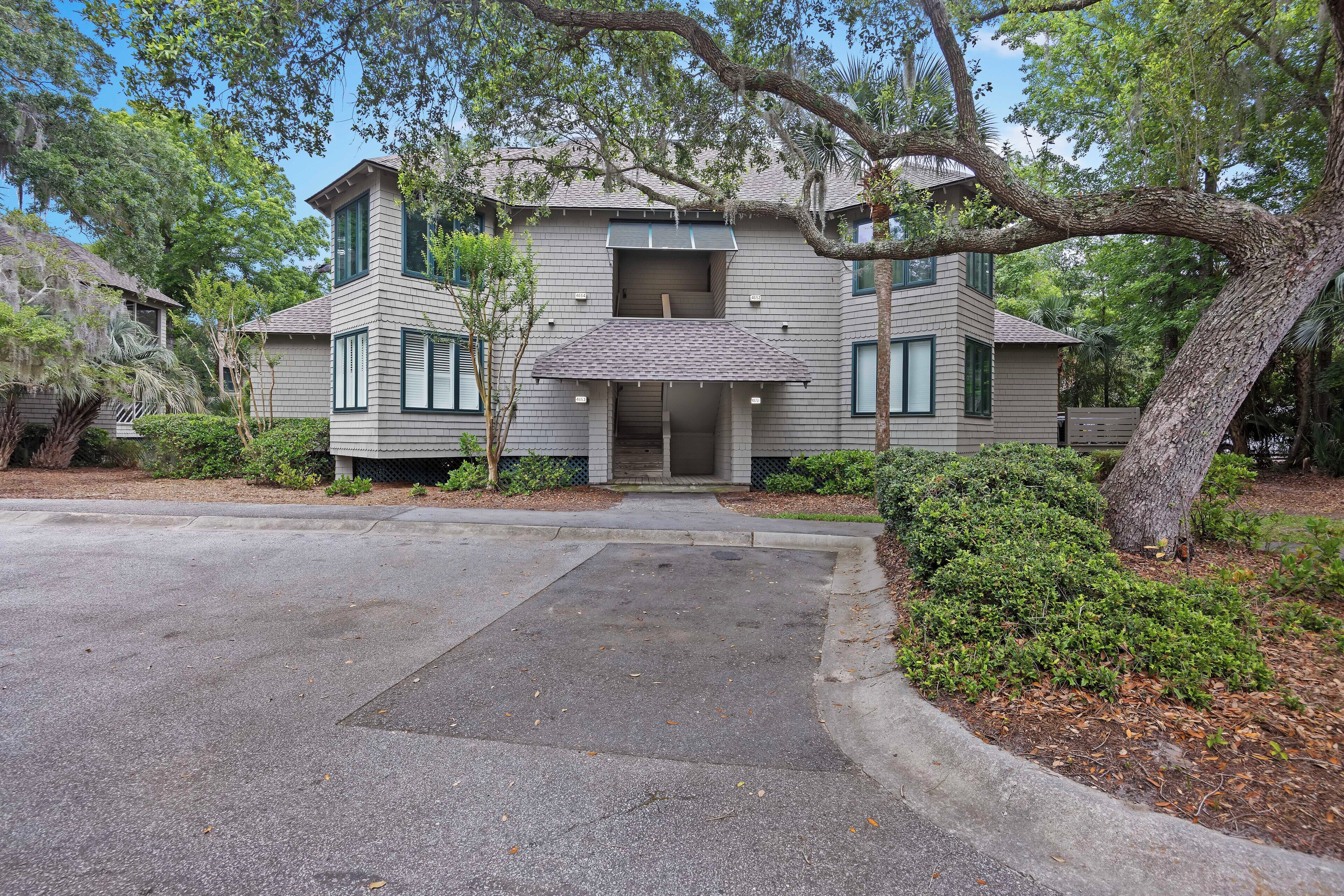 A two-story house with a central entrance, surrounded by a driveway and landscaped garden.