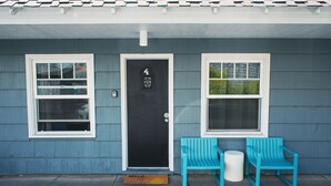 A house with a black door, two windows, and two blue chairs outside. - The Spinn (Manzanita)
