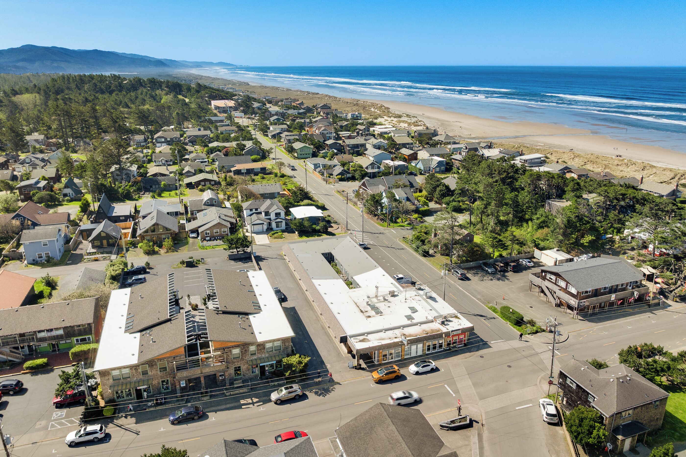 A coastal town with residential houses, a main road, and a beach.