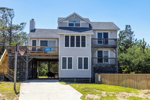 A two-story house with a balcony, a covered porch, and a wooden deck. - Joint Venture: Private Pool, Short Walk to Beach and Currituck Lighthouse (Corolla)