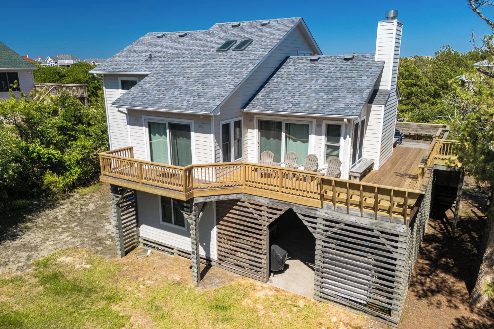 Une maison à deux étages avec un balcon, une terrasse couverte et une cheminée.
