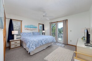 A bedroom with a bed, a ceiling fan, a desk with a computer, and a window with curtains. - Joint Venture: Private Pool, Short Walk to Beach and Currituck Lighthouse (Corolla)