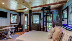 Una habitación acogedora con cama, una mesa y chimenea.