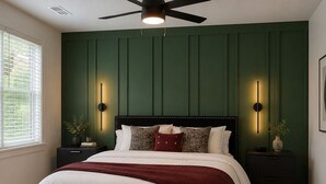 Una camera da letto con un letto, una ventola a soffitto, comodini e illuminazione a parete.