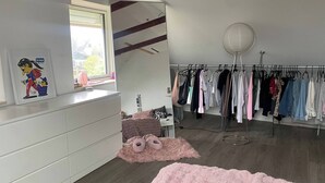A bedroom with a bed, a dresser, a window, a clothes rack, and a pink fluffy rug. - Big House in Beautiful Area (Rødovre)