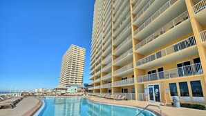 A hotel with a large pool, multiple balconies, and a view of the ocean. - Best View On The Beach.  Complimentary beach service. (Panama City Beach)