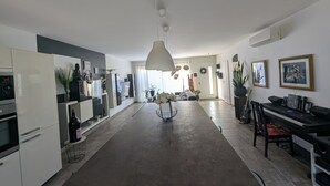 Una cocina amplia con una isla central, electrodomésticos modernos y un comedor con piano.