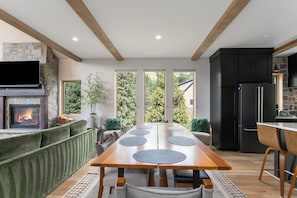 A modern kitchen with a large island, built-in appliances, and a stone fireplace.