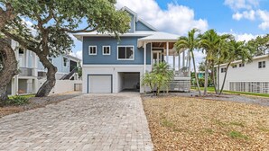 A two-story house with a covered porch, a garage, and a paved driveway.