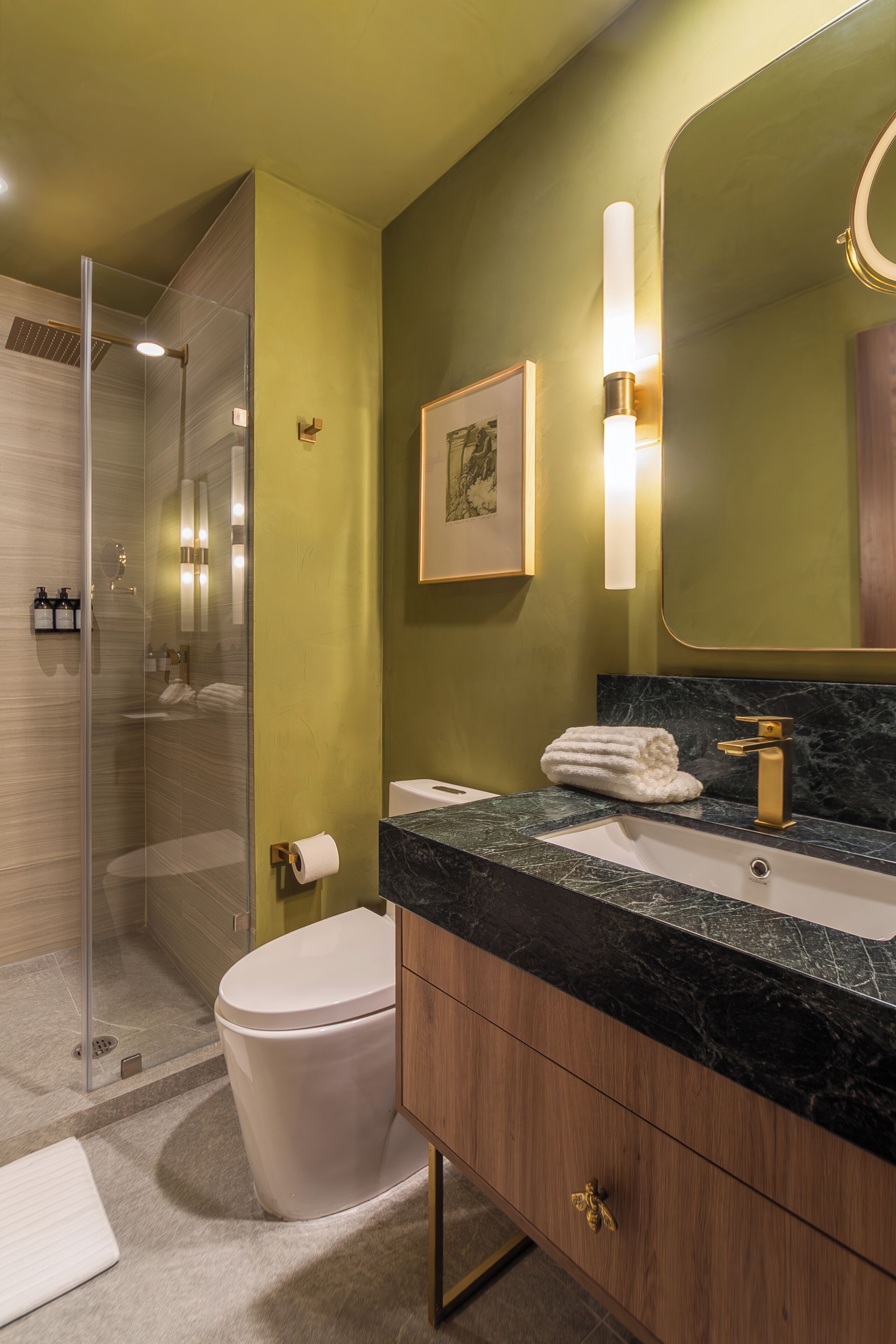 A modern bathroom with a glass-enclosed shower, a marble sink, and a large mirror.