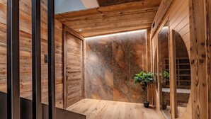 Un intérieur en bois avec un mur en marbre, un escalier et une plante en pot.