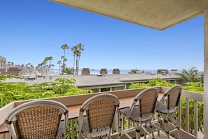 A terrace with wicker chairs and a view of the beach.