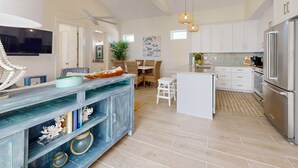 A spacious kitchen with white cabinets, a large island, and a modern stainless steel refrigerator. - Beach Access, Private Hot Tub, Pet Friendly, Shared Pool (Port Aransas)