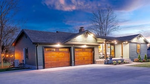 A two-story house with a garage, a covered porch, and a well-maintained lawn.