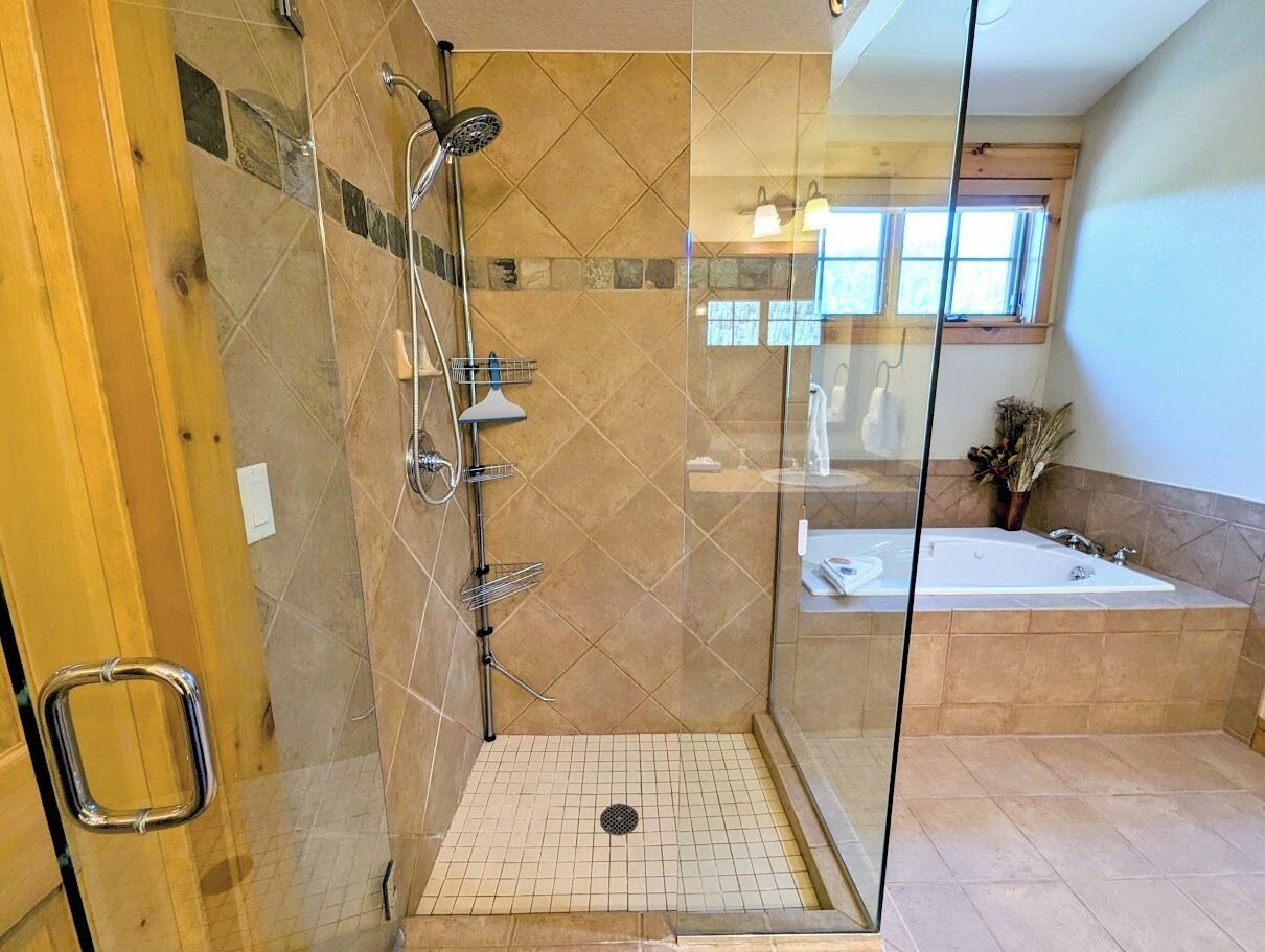 Uma casa de banho moderna com chuveiro em cabine de vidro, banheira e lavatório.