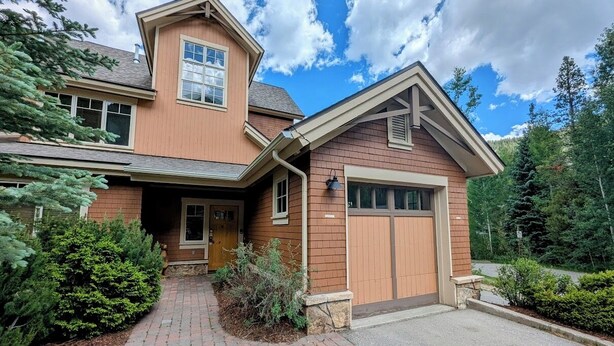 A two-story house with a brick exterior, a front porch, and a garage. - Settlers Creek 6521 (Keystone)