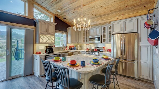 A spacious kitchen with a large island, stainless steel appliances, and a wooden ceiling. - River Place Retreat- Perfect Retreat for Large Groups or Families (Howard)