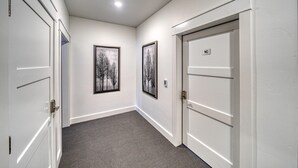 A hallway with white doors, a carpeted floor, and two framed pictures on the walls. - Dog Friendly! The Mayfly Hotel, Unit 1C (Salida)