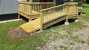 A small wooden cabin with a porch and a covered entryway. - Clinton Cabins #2 (Clinton)